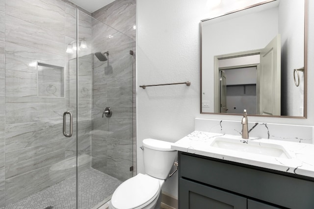 bathroom featuring walk in shower, vanity, and toilet