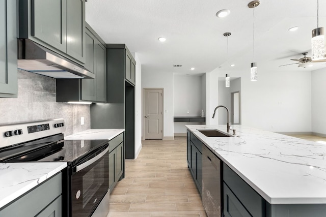 kitchen with decorative light fixtures, light stone counters, sink, and appliances with stainless steel finishes