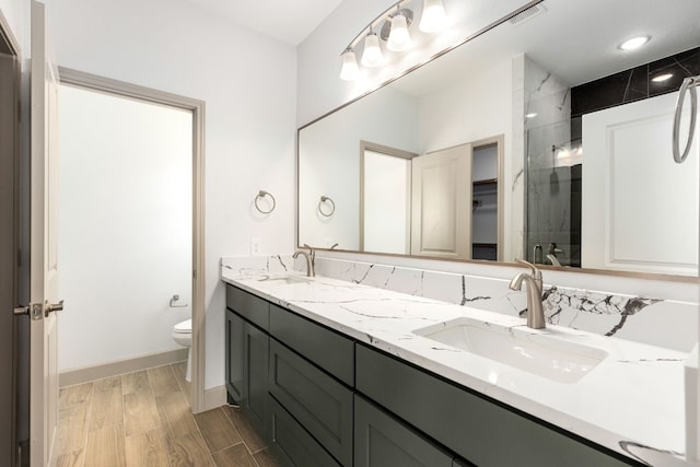 bathroom featuring toilet, an enclosed shower, and vanity