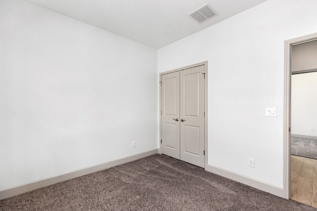 unfurnished bedroom with dark colored carpet