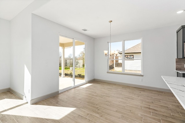 unfurnished dining area with a notable chandelier