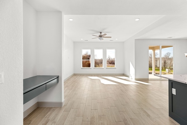 unfurnished living room with ceiling fan