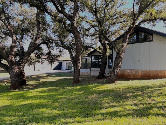 view of front of home with a sunroom and a front yard