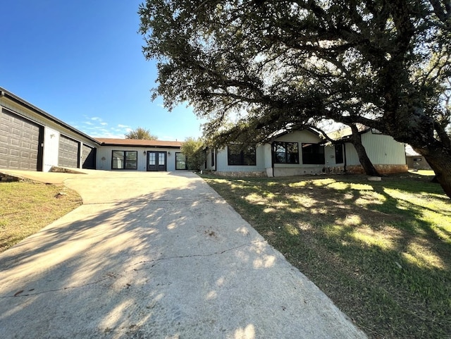 single story home featuring a garage and a front lawn