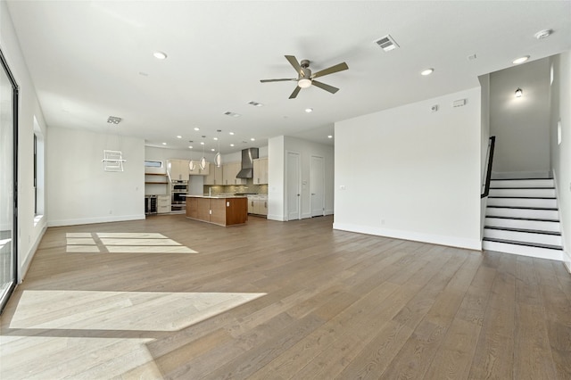 unfurnished living room with ceiling fan and light hardwood / wood-style floors