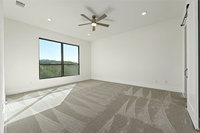 carpeted spare room featuring ceiling fan