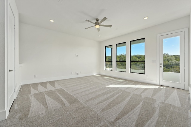 carpeted spare room featuring ceiling fan