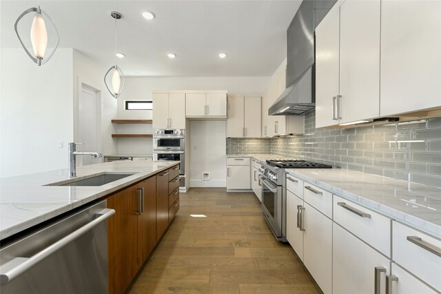 kitchen with tasteful backsplash, hardwood / wood-style floors, light stone countertops, stainless steel appliances, and sink