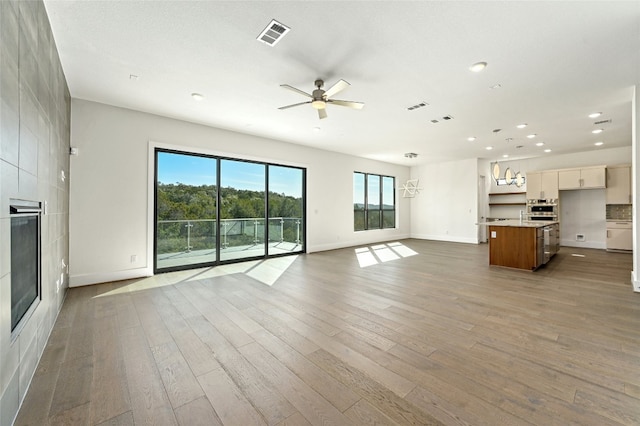 unfurnished living room with hardwood / wood-style floors and ceiling fan