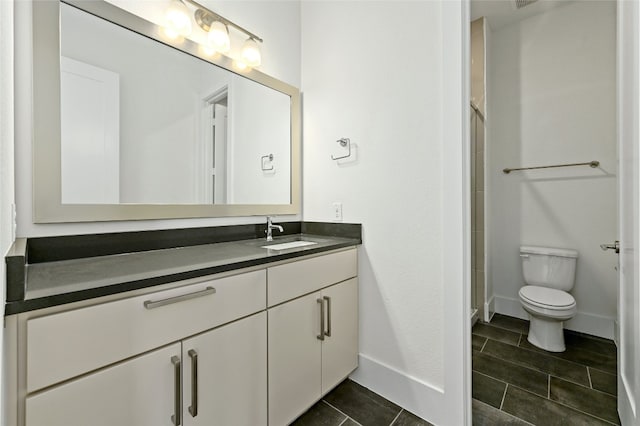 bathroom with toilet, vanity, and tile patterned flooring