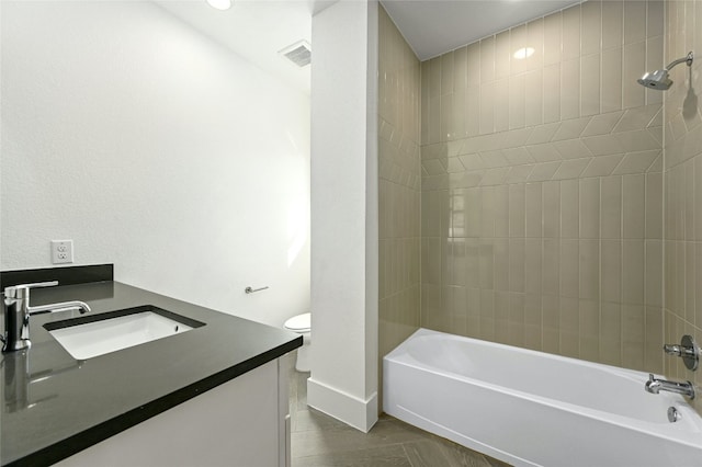 full bathroom featuring tiled shower / bath combo, vanity, and toilet