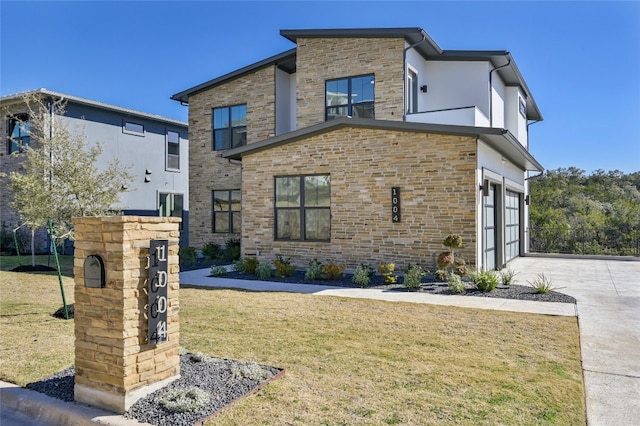 contemporary home featuring a front yard and a garage