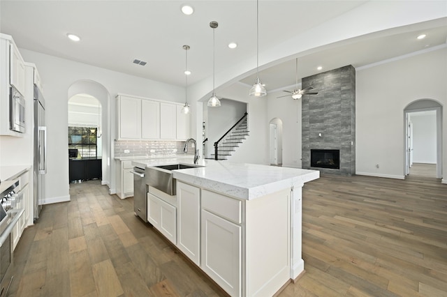 kitchen featuring hardwood / wood-style flooring, sink, a fireplace, and white cabinetry