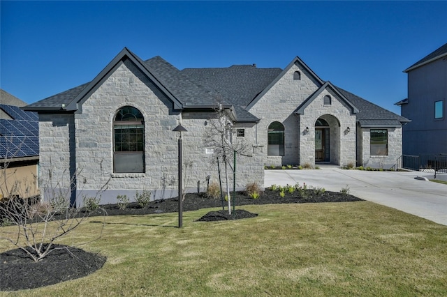 french country inspired facade with a front yard