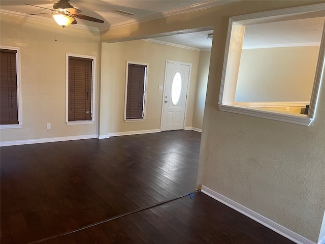 entryway featuring ceiling fan, crown molding, and dark wood-type flooring