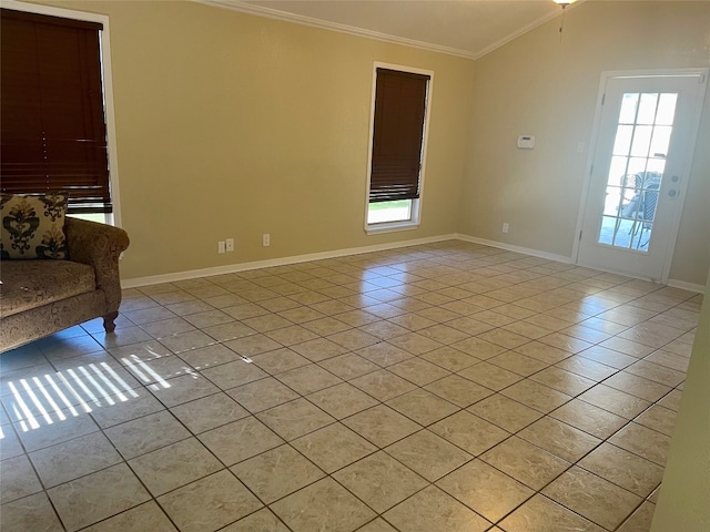 empty room with crown molding, light tile floors, and a wealth of natural light