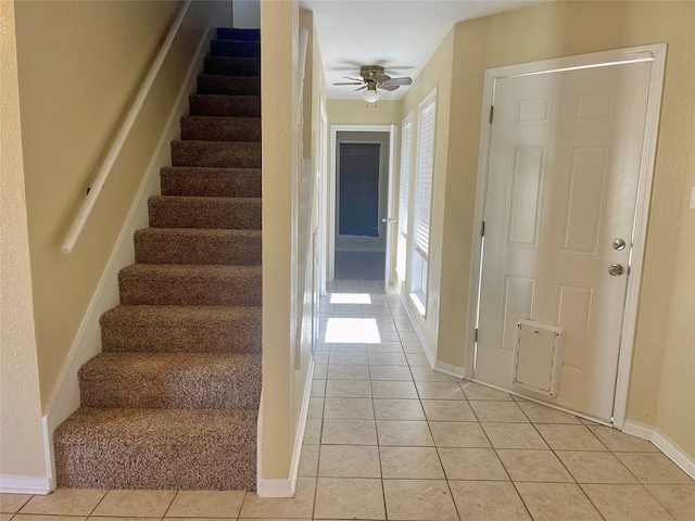 staircase with ceiling fan and light tile flooring