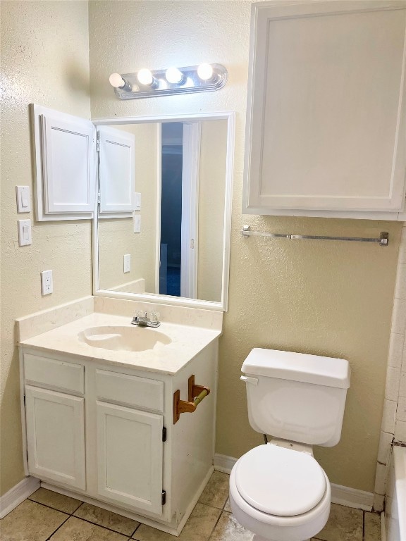 bathroom with vanity, tile floors, and toilet