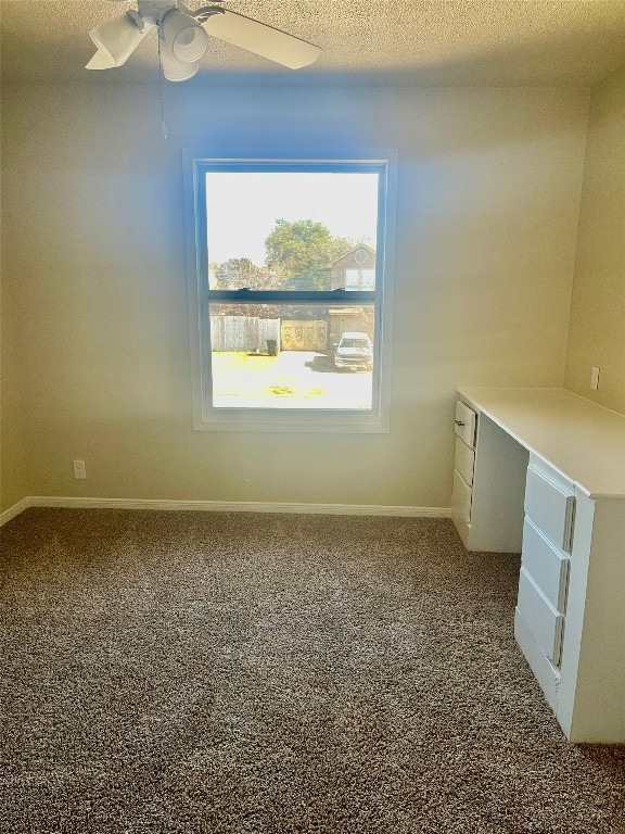 carpeted spare room with ceiling fan and a textured ceiling