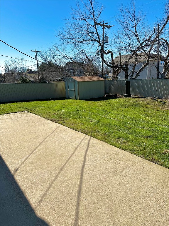 view of yard with a storage unit and a patio