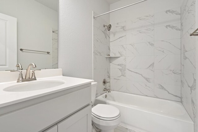 full bathroom featuring vanity, tiled shower / bath combo, and toilet