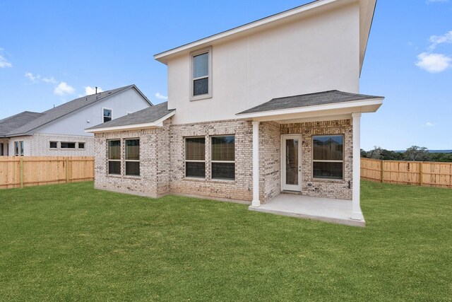 back of house featuring a patio and a yard