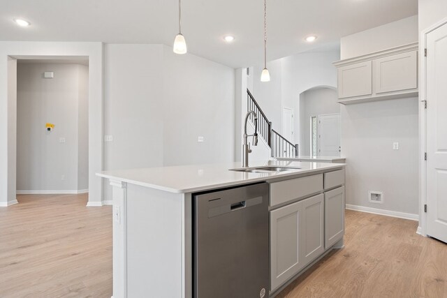 kitchen featuring sink, gray cabinetry, dishwasher, an island with sink, and pendant lighting