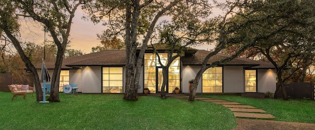 back house at dusk with a yard