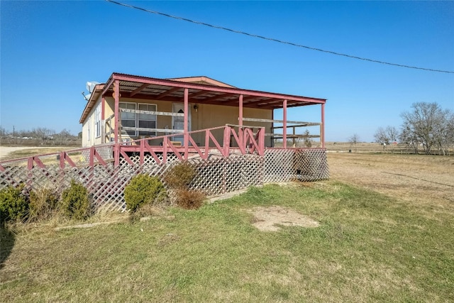 rear view of house featuring a deck and a yard