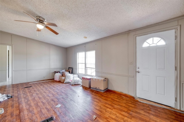 foyer entrance featuring ceiling fan, light wood-type flooring, and a textured ceiling