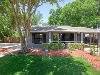 single story home featuring a front lawn, a porch, and a carport