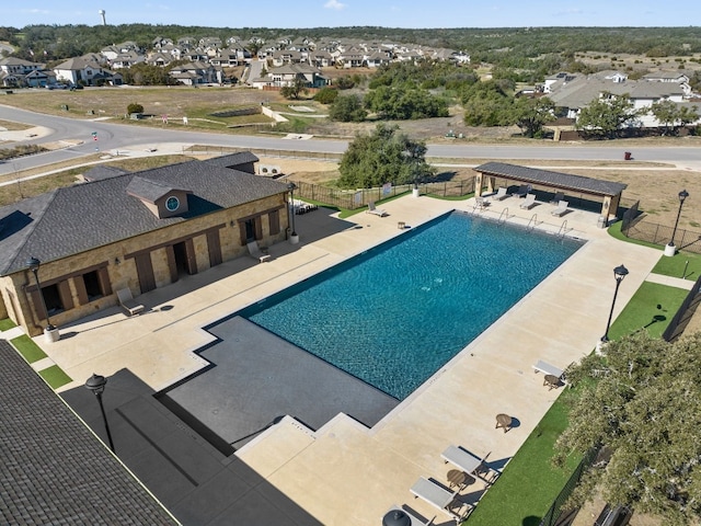 pool featuring a residential view, a patio area, and fence