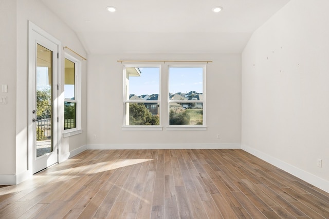 unfurnished room featuring light hardwood / wood-style floors and vaulted ceiling