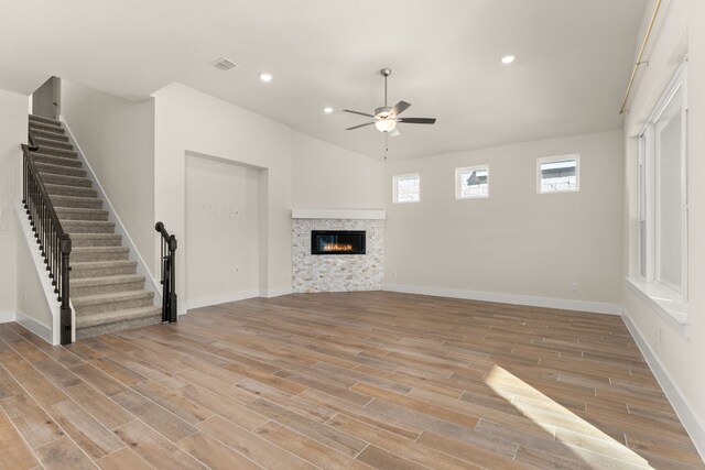 unfurnished living room featuring recessed lighting, light wood-style flooring, a ceiling fan, and a glass covered fireplace