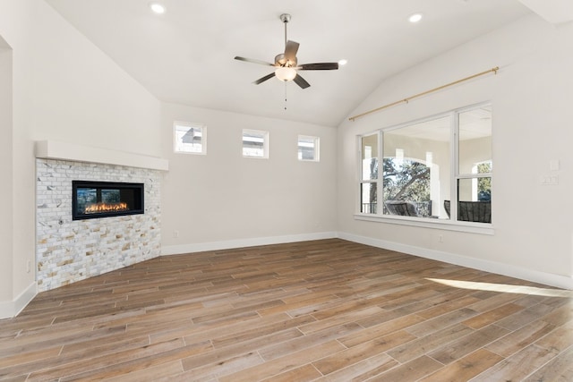 unfurnished living room with ceiling fan, vaulted ceiling, baseboards, and wood finished floors