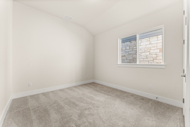 unfurnished room with carpet, visible vents, lofted ceiling, and baseboards