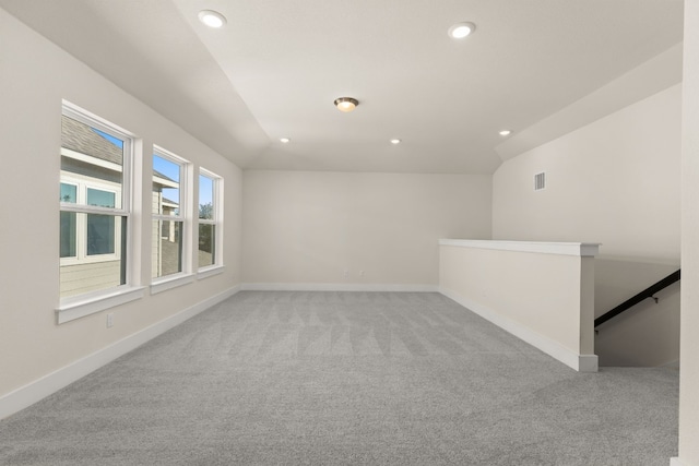 carpeted empty room with lofted ceiling