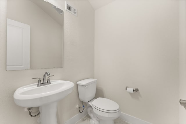 bathroom with toilet, a sink, visible vents, and baseboards