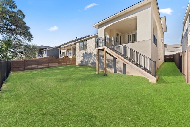 view of yard featuring a fenced backyard and stairway