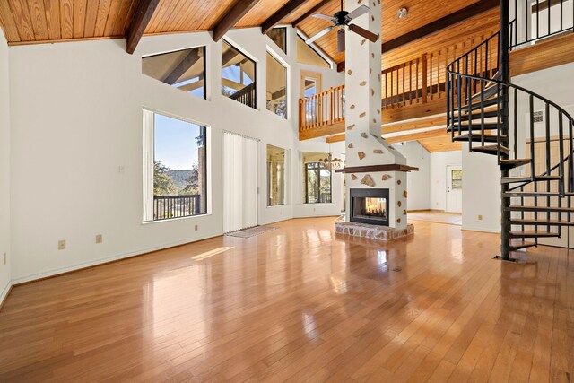 unfurnished living room with ceiling fan, beamed ceiling, light hardwood / wood-style floors, and high vaulted ceiling