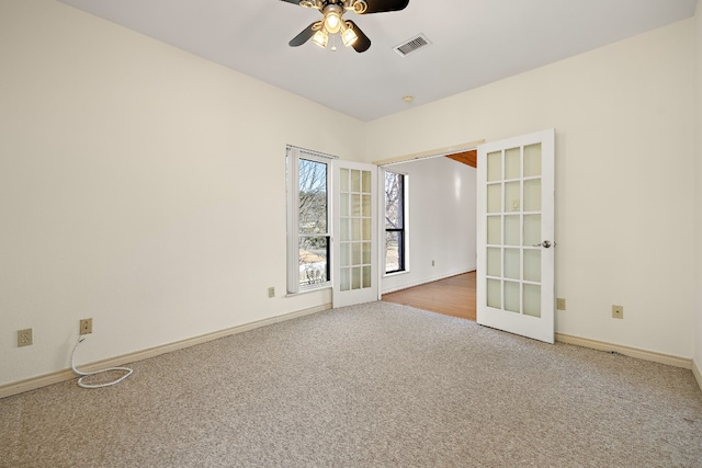 carpeted spare room with ceiling fan and french doors