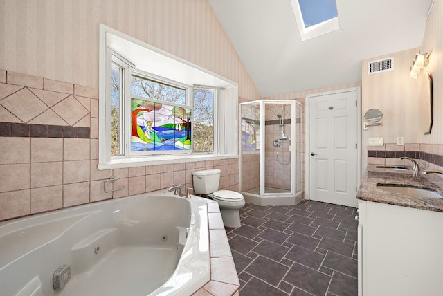 full bathroom with toilet, vanity, a skylight, and independent shower and bath