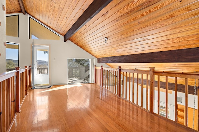 interior space featuring vaulted ceiling with beams, light wood-type flooring, and wooden ceiling