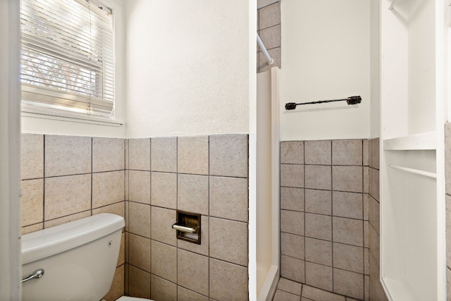 bathroom with toilet, tile walls, and a shower with curtain