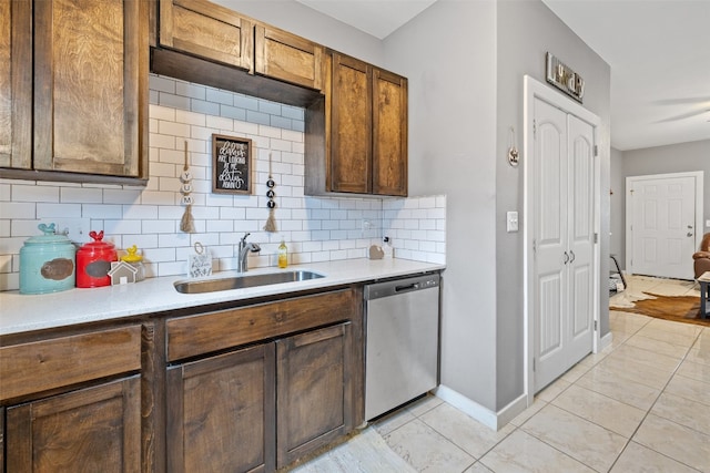 kitchen featuring light tile flooring, sink, backsplash, and dishwasher