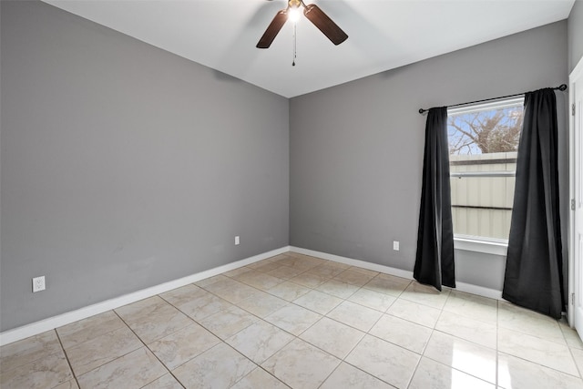 empty room with ceiling fan and light tile flooring