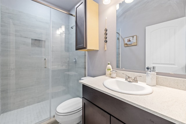 bathroom with toilet, vanity with extensive cabinet space, and walk in shower