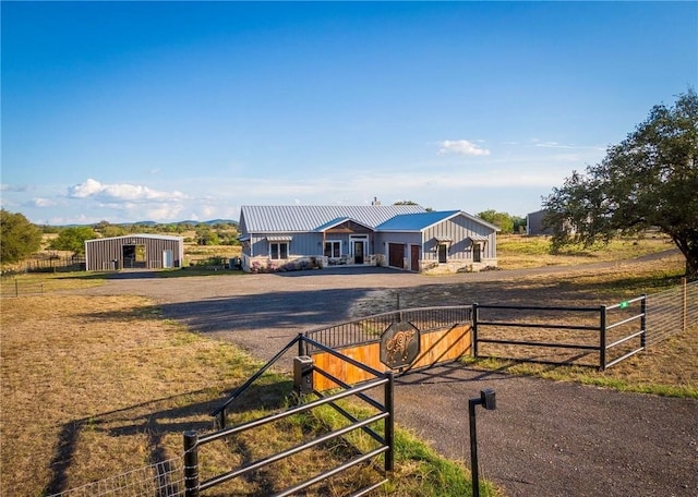 view of front of property featuring an outdoor structure and a rural view