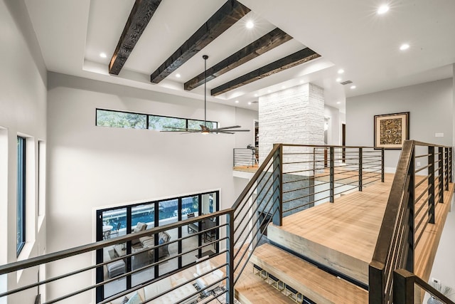 stairway featuring ceiling fan and beam ceiling