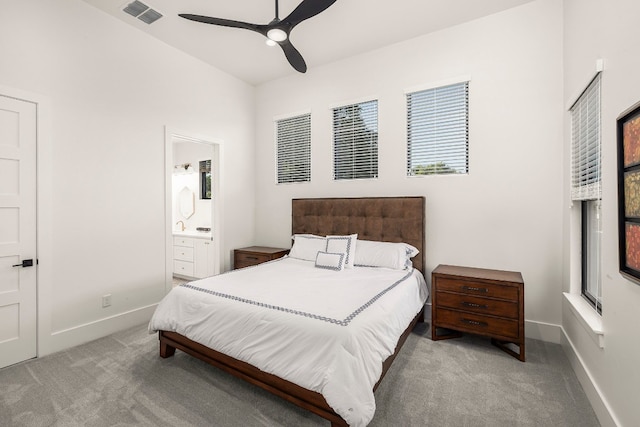 bedroom with ensuite bathroom, ceiling fan, and light colored carpet